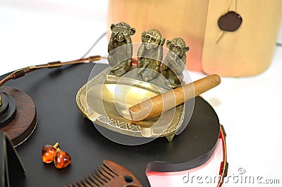 Copper ashtray with cigar and monkeys and amber earrings Stock Photo