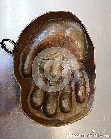 Copper ashtray in the form of a hand for receiving coins Stock Photo