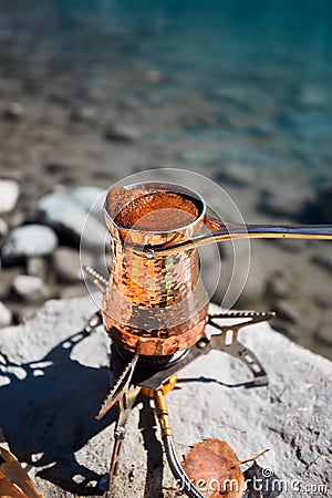 Copper Cezve for coffee in autumn lake camping in the mountains Stock Photo