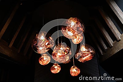 Copper colored glass pendant light fitting hanging in attic with wooden beams Stock Photo