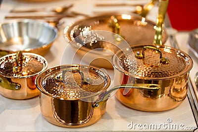 Copper cookware, pots and pans are on the counter in the store. Stock Photo