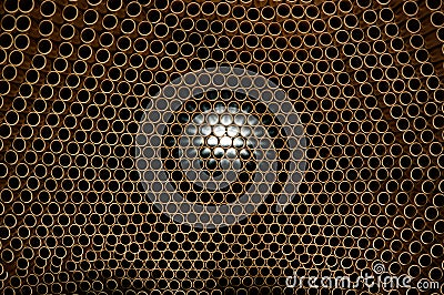 Copper pipes, light penetrates through numerous openings Stock Photo