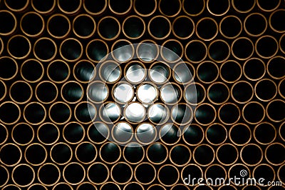 Copper pipes, light penetrates through numerous openings Stock Photo