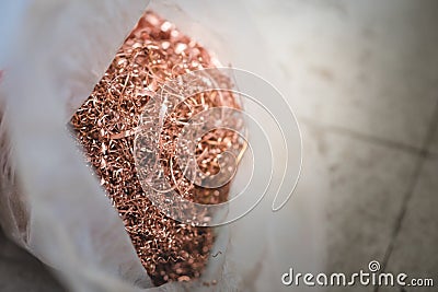 Copper scrap materials recycling. Copper chip waste after machining metal parts on a cnc lathe. Closeup twisted spiral copperl Stock Photo
