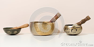 Copper singing bowl and wooden clapper on a white table. Musical instrument for meditation, relaxation, various medical practices Stock Photo