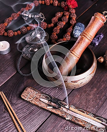 Copper singing bowl and a wooden stick on a brown table Stock Photo