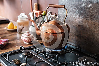 copper vintage kettle on gas stove in modern kitchen Stock Photo