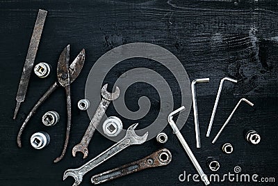 Copy space of working tools on a black wooden surface. Nippers, wrench keys, pliers, screwdriver. Top view. Stock Photo