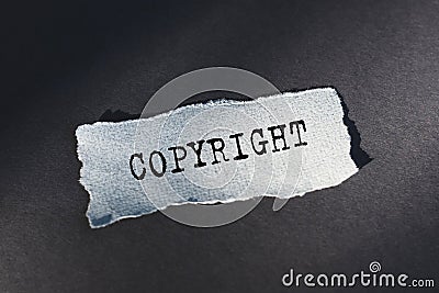 Copyright - text on torn paper on dark desk in sunlight Stock Photo