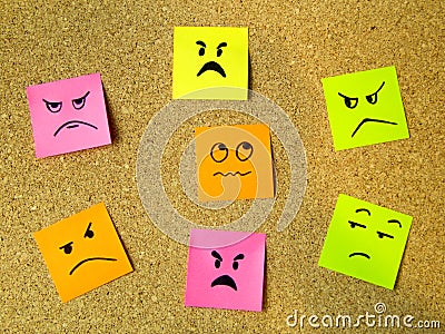 cork board with colorful post its representing various emoticons with anger emotion communication accusing concept Stock Photo
