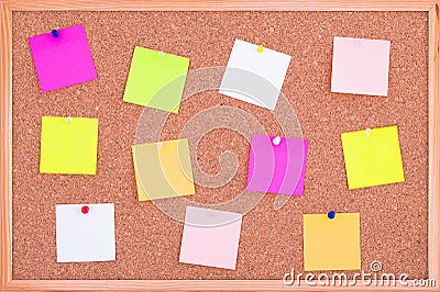 Cork board wood background with post it notes in different radiant colours. Cork board surface. Close up background of cork board. Stock Photo