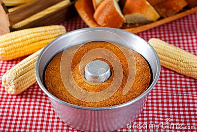 corn cake in the pan baking form on rustic wooden table. Typical Brazilian party food. Selective focus Stock Photo
