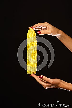 Corn cob in girls fingers. Female hand holds corn Stock Photo