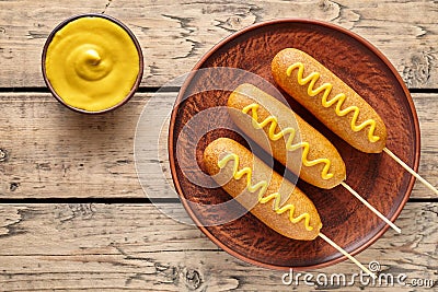 Corn dog traditional American corndog street junk food deep fried hotdog meat sausage snack with yellow mustard Stock Photo