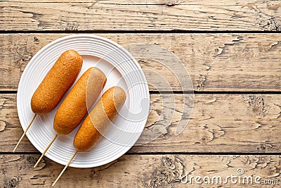 Corn dog traditional American street food deep fried hot sausage snack on white plate Stock Photo