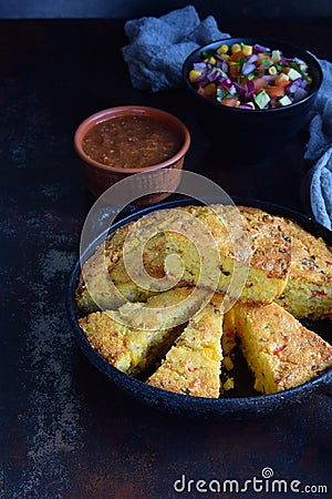 Cornbread and other mexican food - salsa with tomato, red onion, lime, cilantro, corn and hot pepper sauce. Copy space. Stock Photo