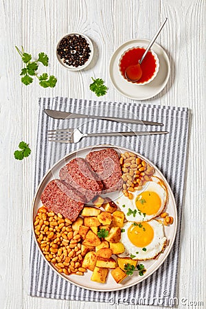 corned beef, baked beans, potatoes and fried eggs Stock Photo