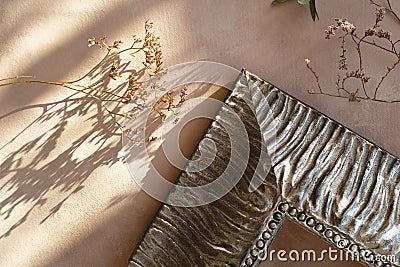 Corner of ornamental silver wooden picture frame and dried flowers on pastel beige canvas backdrop. Home decoration. Stock Photo