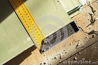 Corner ruler on drywall sheets. The stack of gypsum board preparing for construction. View from above. Stock Photo