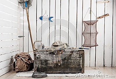 Corner of wooden room with things for fishing and big old chest Stock Photo