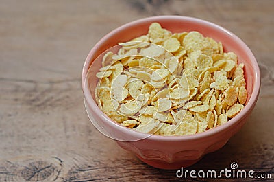Cornflakes in a pink bowl, on a wooden table. copy space Stock Photo