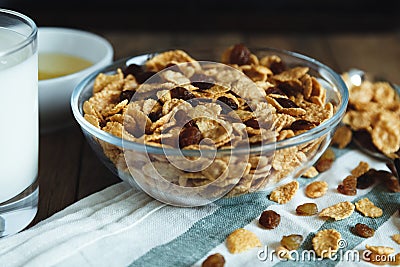 Cornflakes with raisins in bowl on a wooden table Stock Photo