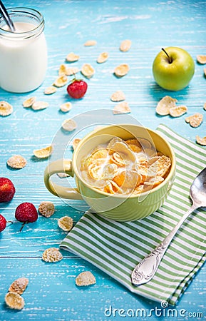 Cornflakes with strawberry, apple and jar milk on wooden table Stock Photo