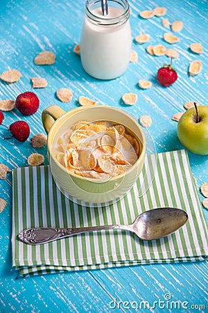 Cornflakes with strawberry, apple and jar milk on wooden table Stock Photo