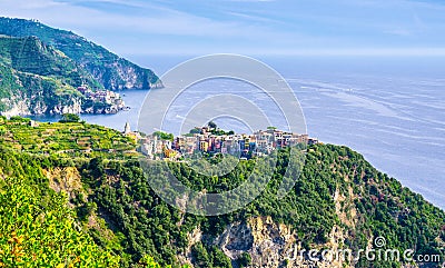 Corniglia traditional typical Italian village with colorful buildings on rock cliff and Manarola, Genoa Gulf, Ligurian Sea, blue s Stock Photo