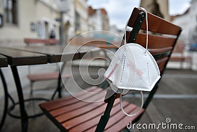 Corona crisis - lockdown - FFP2 mask hangs on a chair in an empty beer garden in Steyr, Austria, Europe Stock Photo