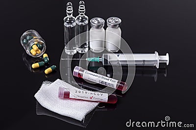 Coronavirus blood tube test with syringe and ampoules on a black background Stock Photo