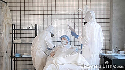 Coronavirus covid-19 Infected Patient on bed in Quarantine Room at Hospital with Disease Control Doctors Wearing Hazmat Stock Photo
