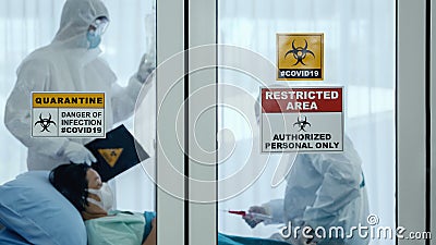 Coronavirus covid-19 quarantine and breakout alert sign on window of quarantine room at hospital with disease control experts try Stock Photo