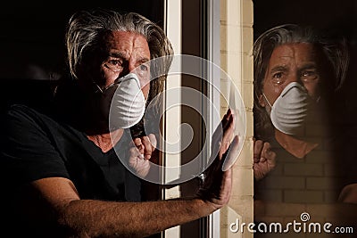 Coronavirus crying male medical mask quarantine self isolation concept, reflection of man with tears in protective mask, covid-19 Stock Photo