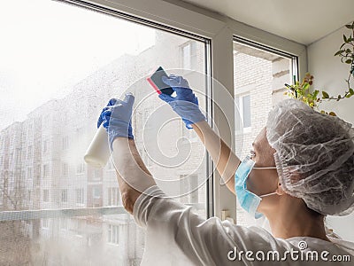 Coronavirus disinfection. People in making disinfection on windows. Doctor in rubber gloves disinfects windows Stock Photo