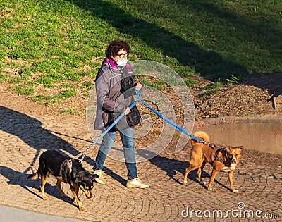 Coronavirus Italy in quarantine woman with mask and dogs Editorial Stock Photo