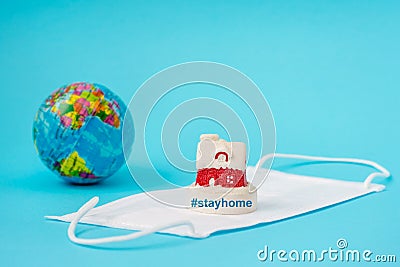 Coronavirus prevention, mask and globe, stay home on light blue background Stock Photo