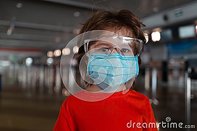 Coronavirus protection. Child face in a mask and goggles. The boy wears a medical mask and glasses. Childrens health and Stock Photo