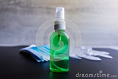 Coronavirus protective equipment - medical protective mask, disposable gloves and green antiseptic disinfectant spray Stock Photo