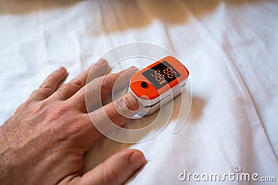 Coronavirus symptoms concept. Pulse Oximeter digital device monitoring oxygen saturation and pulse Stock Photo