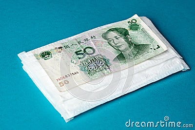 Coronavirus Wuhan illness concept. Chinese money and medical mask Stock Photo