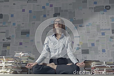 Corporate businesswoman practicing meditation in the office Stock Photo