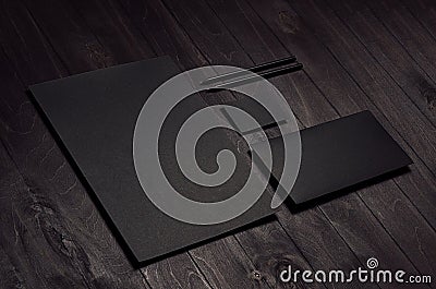 Corporate identity set of blank black letterhead, envelope, business card on dark wood board, inclined. Stock Photo