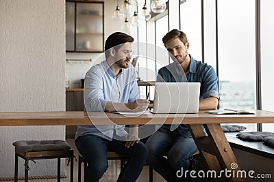 Corporate mentor explaining content on laptop to intern Stock Photo