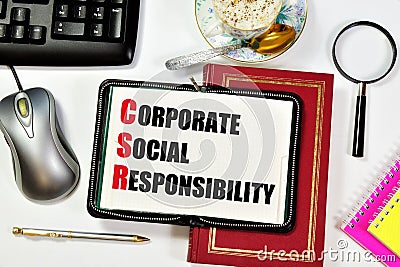 Corporate social responsibility. Text inscription in the research notebook on the textbook. Stock Photo