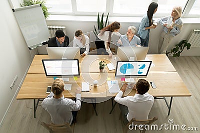 Corporate staff working in office together using computers and t Stock Photo
