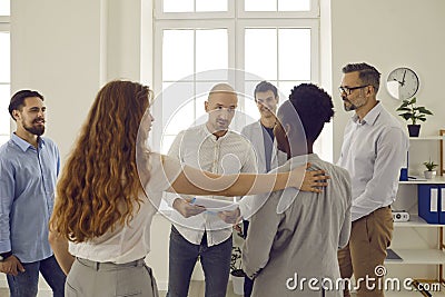 Corporative business training in office with people standing in round and listening man colleague. Stock Photo