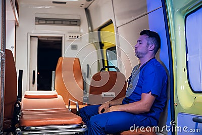 Corpsman in uniform sit and breathe out in the ambulance car Stock Photo