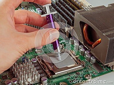Correct application of thermal conductive paste to the cover of a computer or server circuit before installing the radiator of the Stock Photo