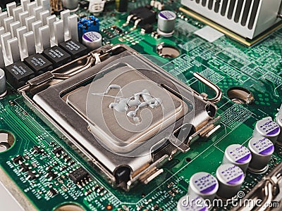 Correct application of thermal conductive paste to the cover of a computer or server circuit before installing the radiator of the Stock Photo